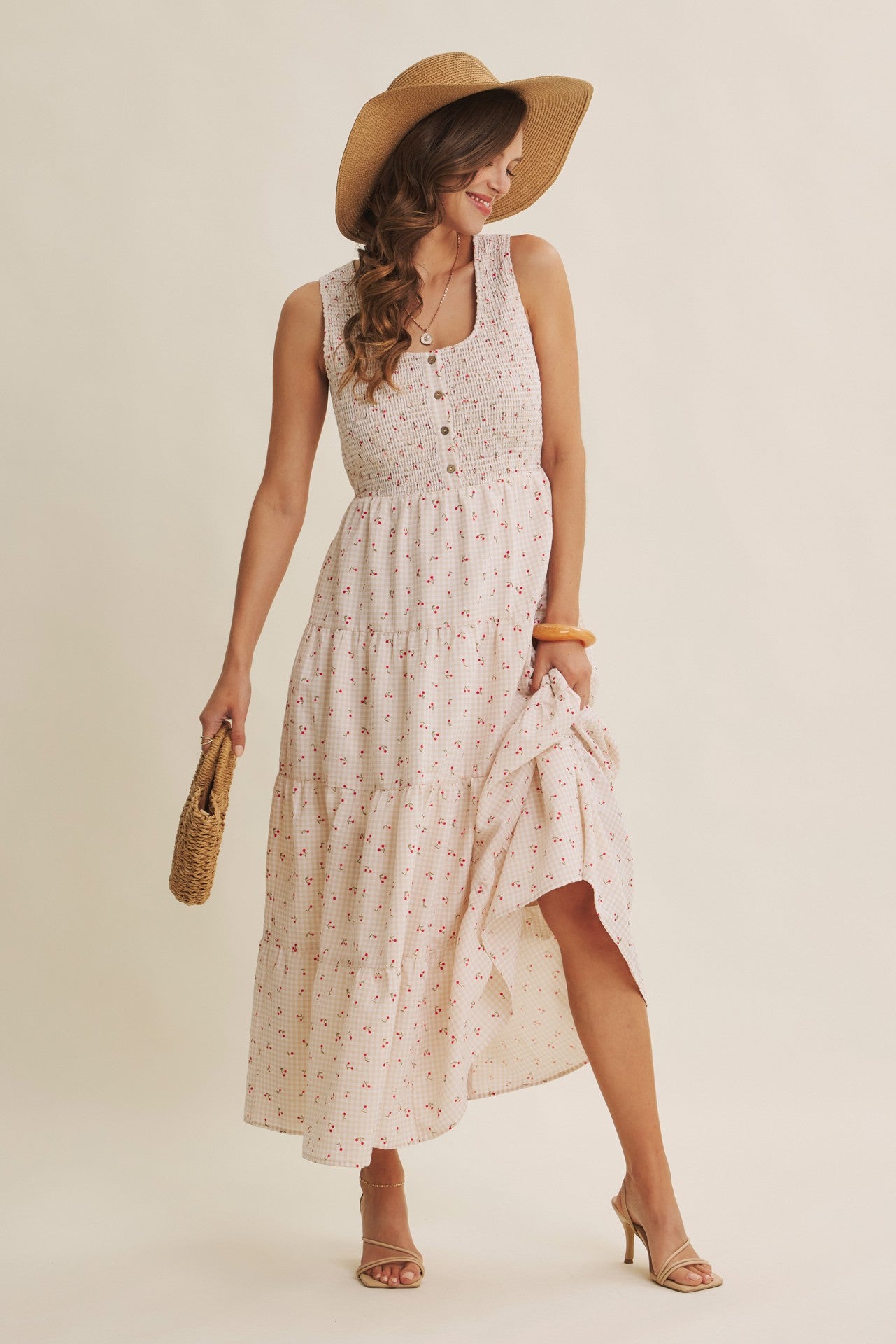 Cherry gingham print maxi dress in the color biscuit. The dress has a smocked bust, round neck, button-down detail, side pockets and comes lined. 