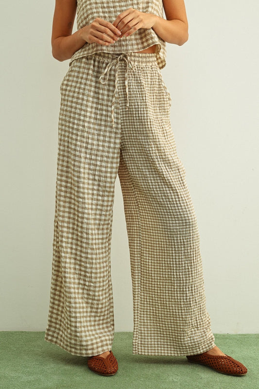 Tan and cream mixed gingham print pants featuring a high-rise elastic drawstring waistband, a relaxed straight-leg silhouette, and a lightweight textured fabric.