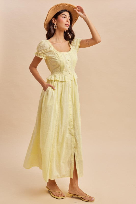 Maxi Dress in Lemon Water Yellow is a lightweight, feminine yellow maxi dress featuring delicate Swiss dot fabric, puff sleeves, and a flattering button-front bodice