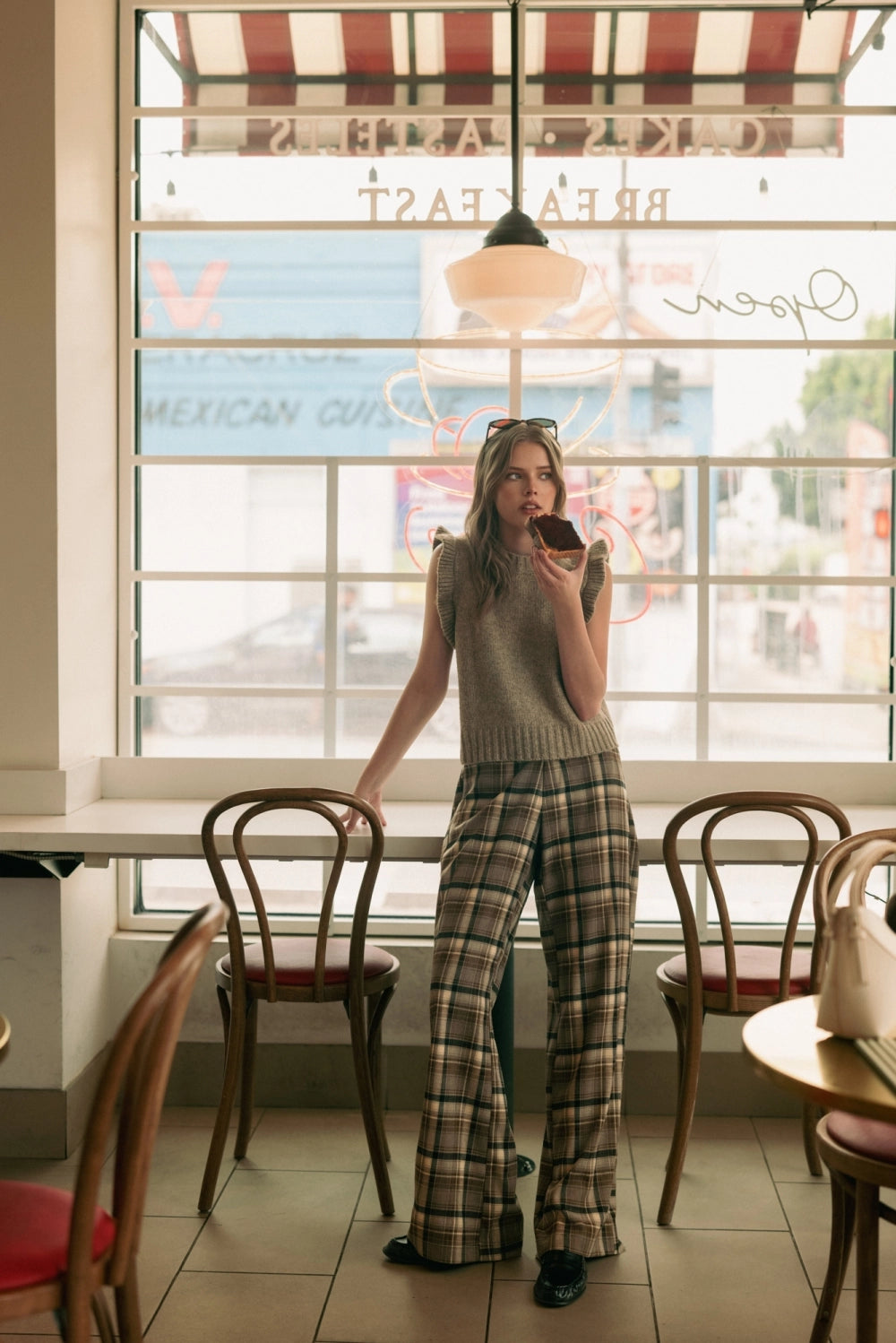 A women's high-waisted wide-leg plaid trousers in black and warm brown featuring front pleats, belt loops, and a relaxed straight drape.