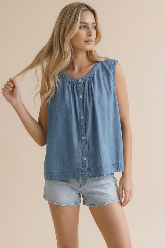 A sleeveless washed blue denim top featuring a functional button-down front, a rounded neckline with shirred detailing, and a relaxed swing silhouette.