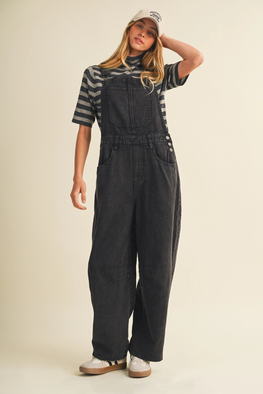 A pair of women's high-waisted wide-leg twill overalls in a vintage washed black denim finish featuring classic adjustable shoulder straps, a front chest pocket, and side pockets.