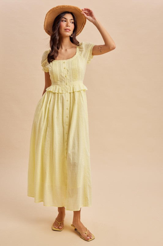 Maxi Dress in Lemon Water Yellow is a lightweight, feminine yellow maxi dress featuring delicate Swiss dot fabric, puff sleeves, and a flattering button-front bodice