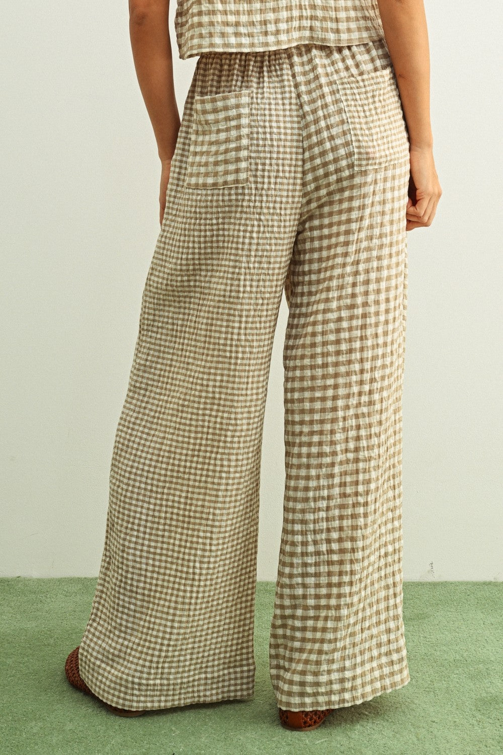 Tan and cream mixed gingham print pants featuring a high-rise elastic drawstring waistband, a relaxed straight-leg silhouette, and a lightweight textured fabric.