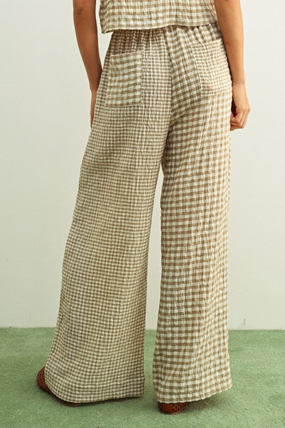 Tan and cream mixed gingham print pants featuring a high-rise elastic drawstring waistband, a relaxed straight-leg silhouette, and a lightweight textured fabric.