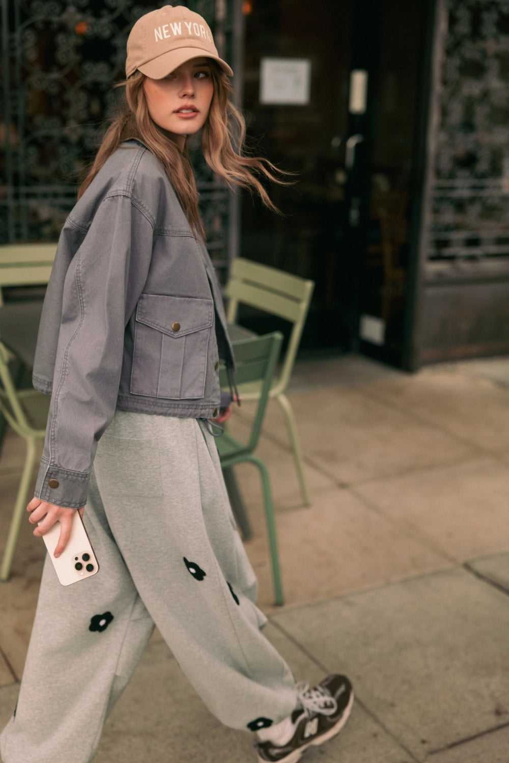 A women's heather gray wide-leg fleece sweatpants featuring an elastic drawstring waistband, relaxed barrel leg, and black chenille flower patches across the front and back.