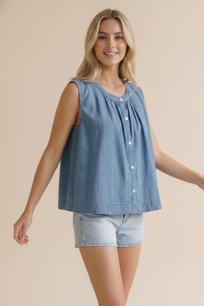 A sleeveless washed blue denim top featuring a functional button-down front, a rounded neckline with shirred detailing, and a relaxed swing silhouette.