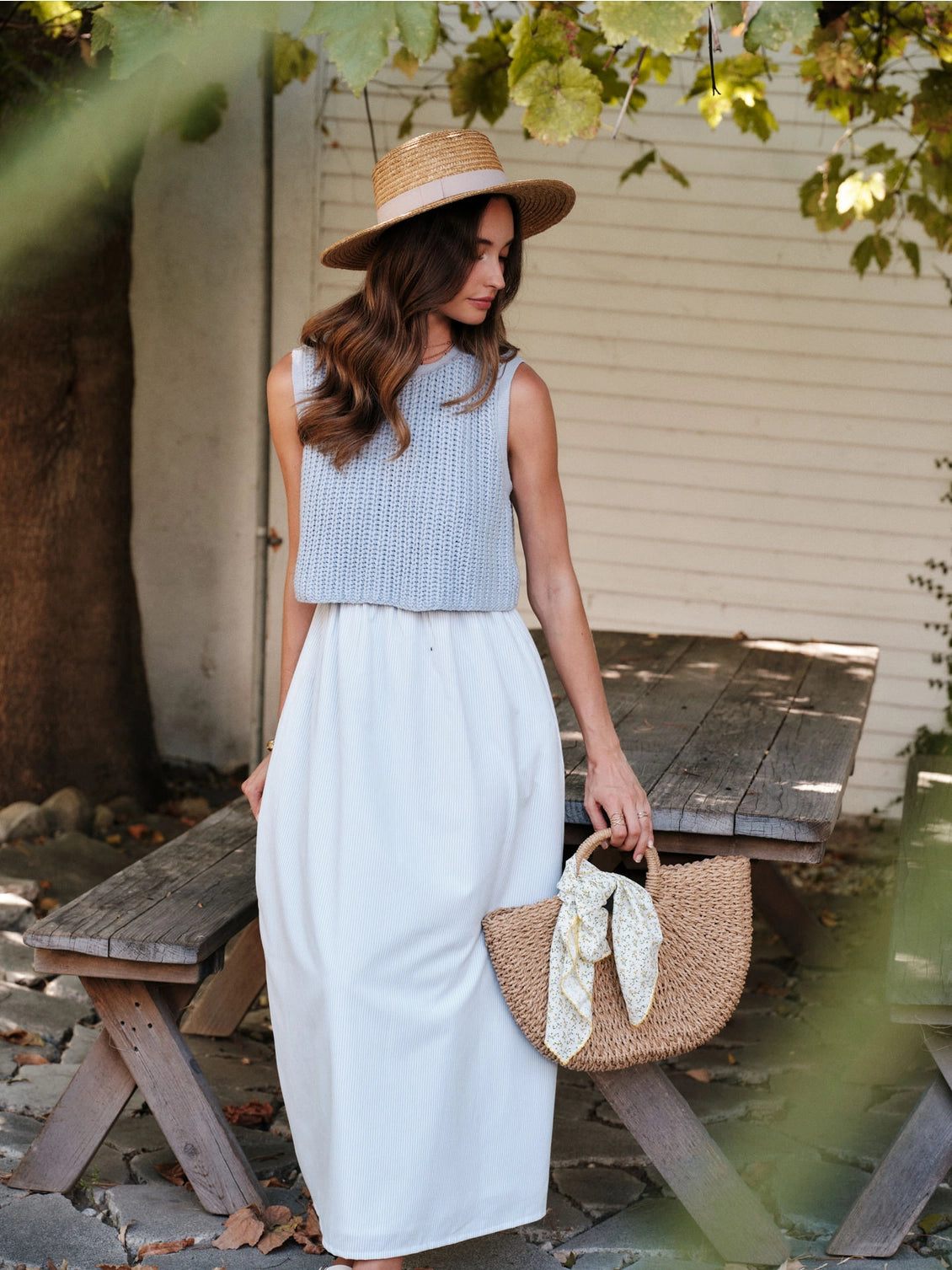A women's sky blue mixed media midi dress featuring a sleeveless open-knit sweater vest top and an attached gathered striped midi skirt.