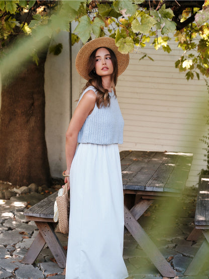 A women's sky blue mixed media midi dress featuring a sleeveless open-knit sweater vest top and an attached gathered striped midi skirt.