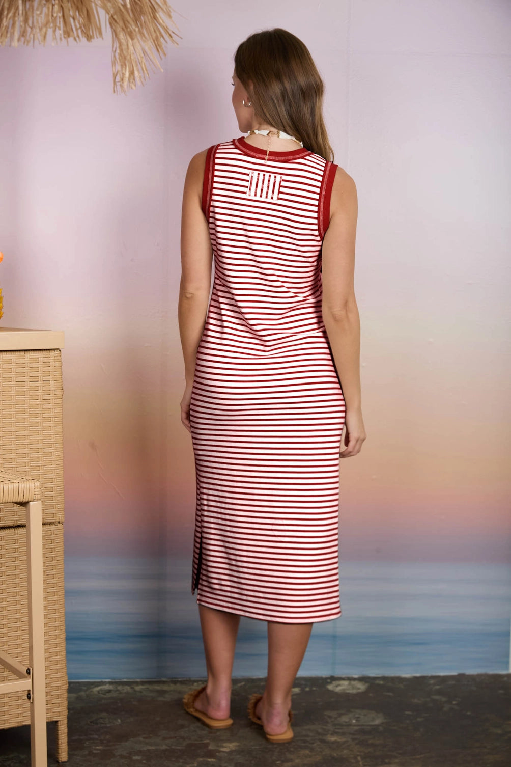 A sleeveless knit midi dress in a red and white horizontal stripe pattern featuring a solid red contrast trim crew neckline and a relaxed column silhouette.