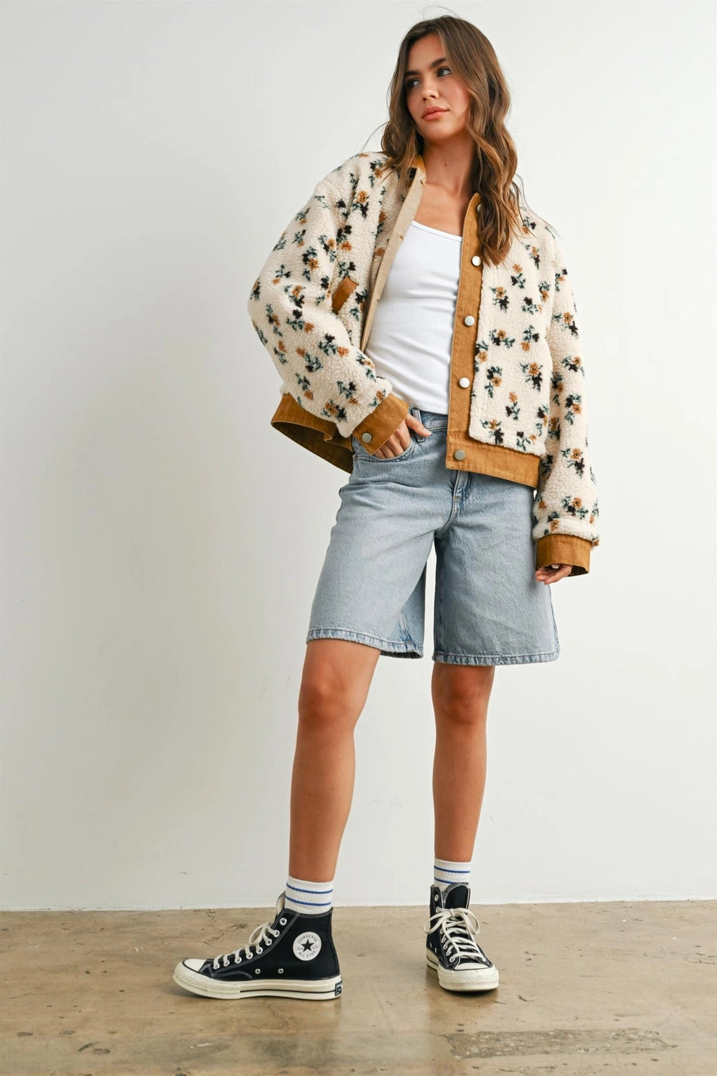 A women's cream floral printed plush sherpa fleece jacket featuring camel brown twill contrast trim, front button closures, and side pockets.