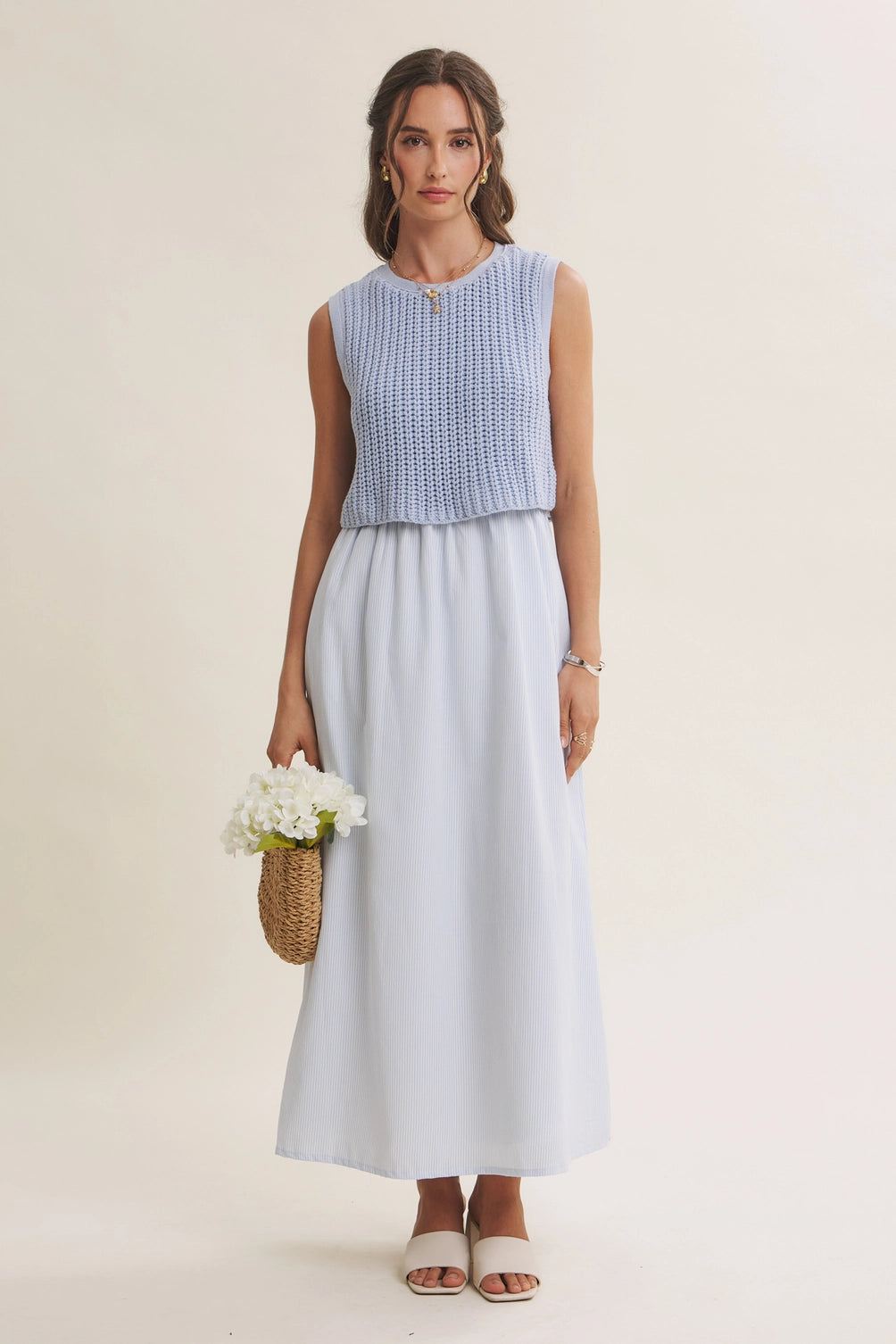 A women's sky blue mixed media midi dress featuring a sleeveless open-knit sweater vest top and an attached gathered striped midi skirt.