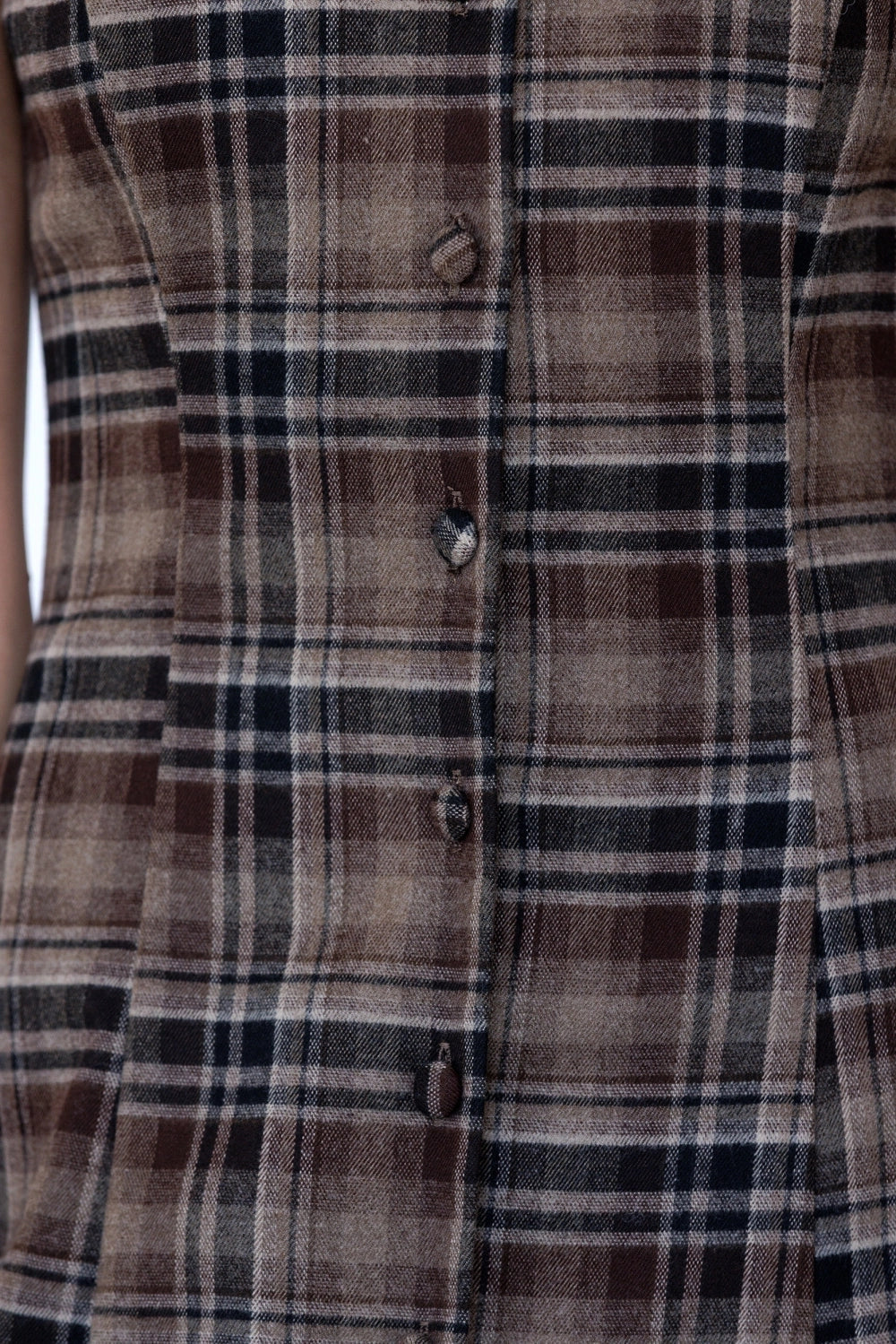 A women's sleeveless midi dress in brown and black plaid featuring a boat neckline, vertical front buttons, and a straight column silhouette.