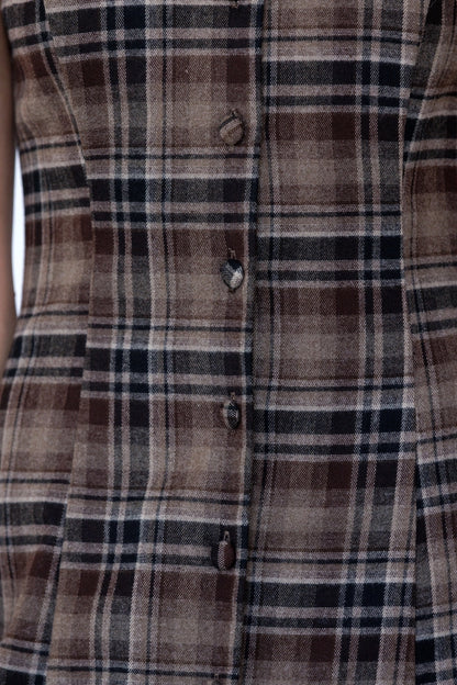 A women's sleeveless midi dress in brown and black plaid featuring a boat neckline, vertical front buttons, and a straight column silhouette.