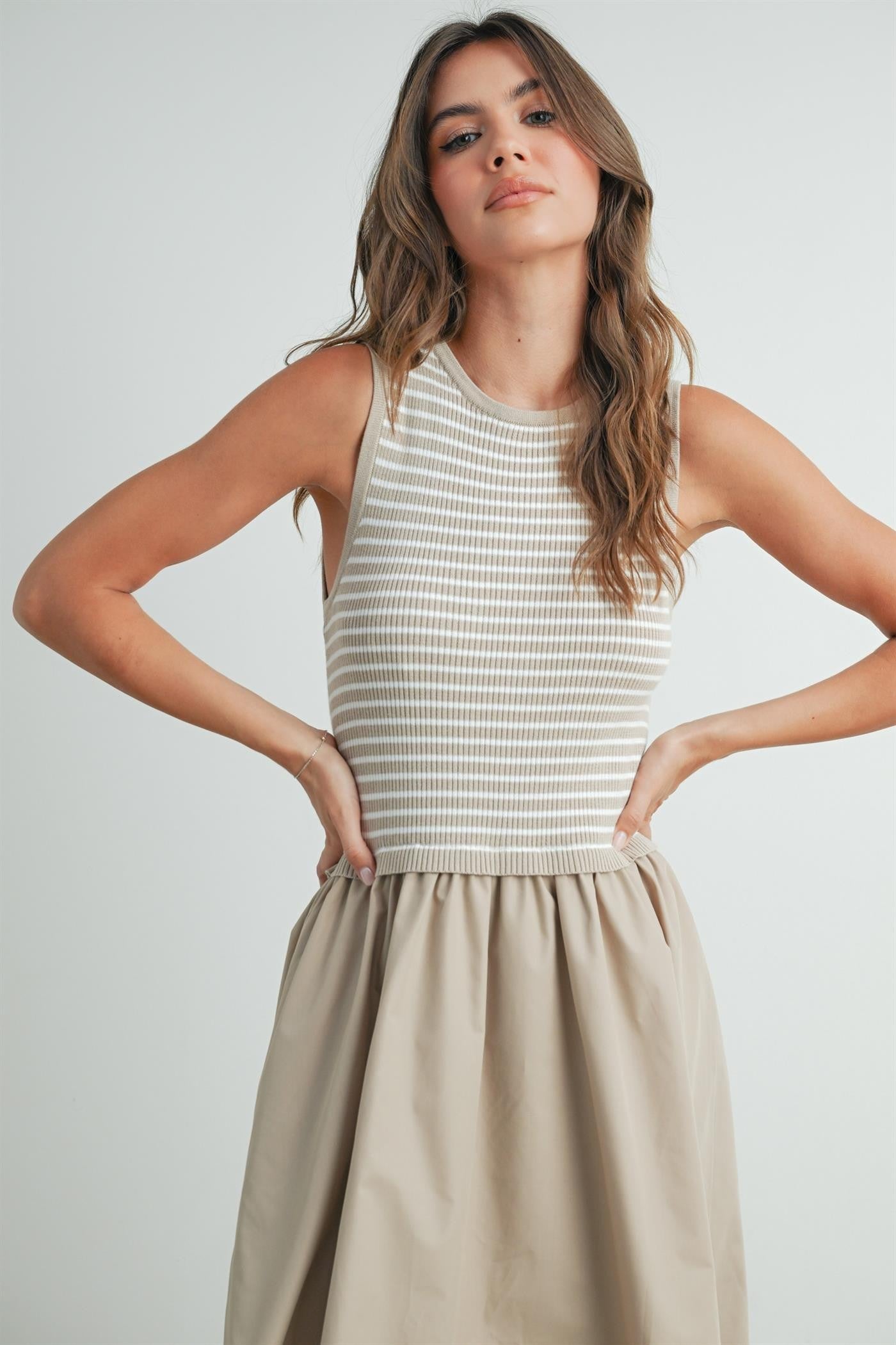 Striped sleeveless dress in taupe and ivory. Contains a solid flowy cotton bottom with a striped smocked top. 