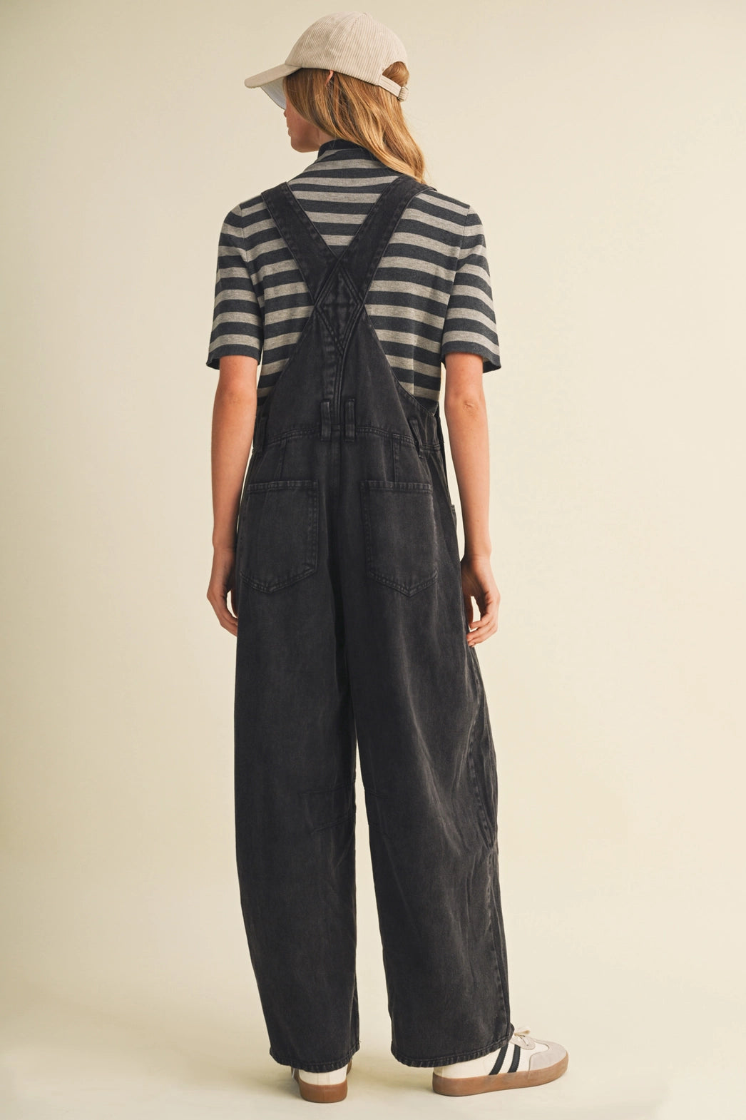 A pair of women's high-waisted wide-leg twill overalls in a vintage washed black denim finish featuring classic adjustable shoulder straps, a front chest pocket, and side pockets.