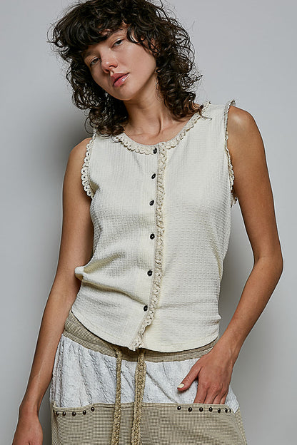 A women's sleeveless cream textured waffle-knit top featuring a button-front closure and delicate eyelet lace trimming along the round neckline and armholes.