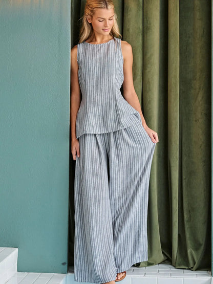A women's two-piece pinstripe clothing set in a muted gray and white color-way featuring a sleeveless high-neck tunic top and matching high-waisted flowing wide-leg pants with side pockets.