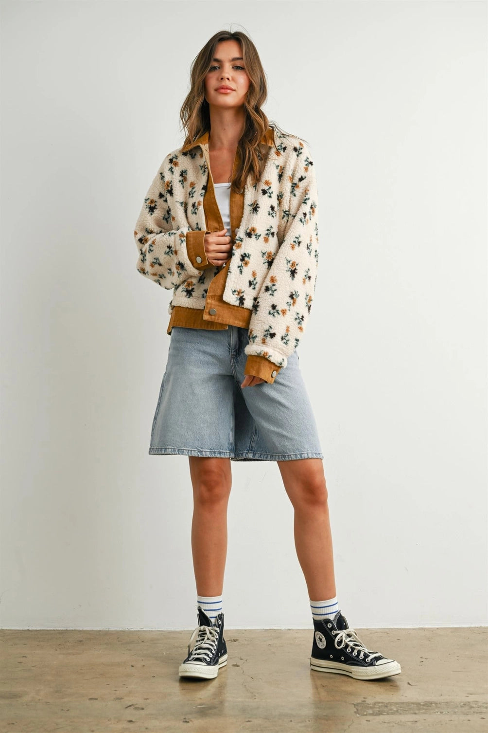 A women's cream floral printed plush sherpa fleece jacket featuring camel brown twill contrast trim, front button closures, and side pockets.