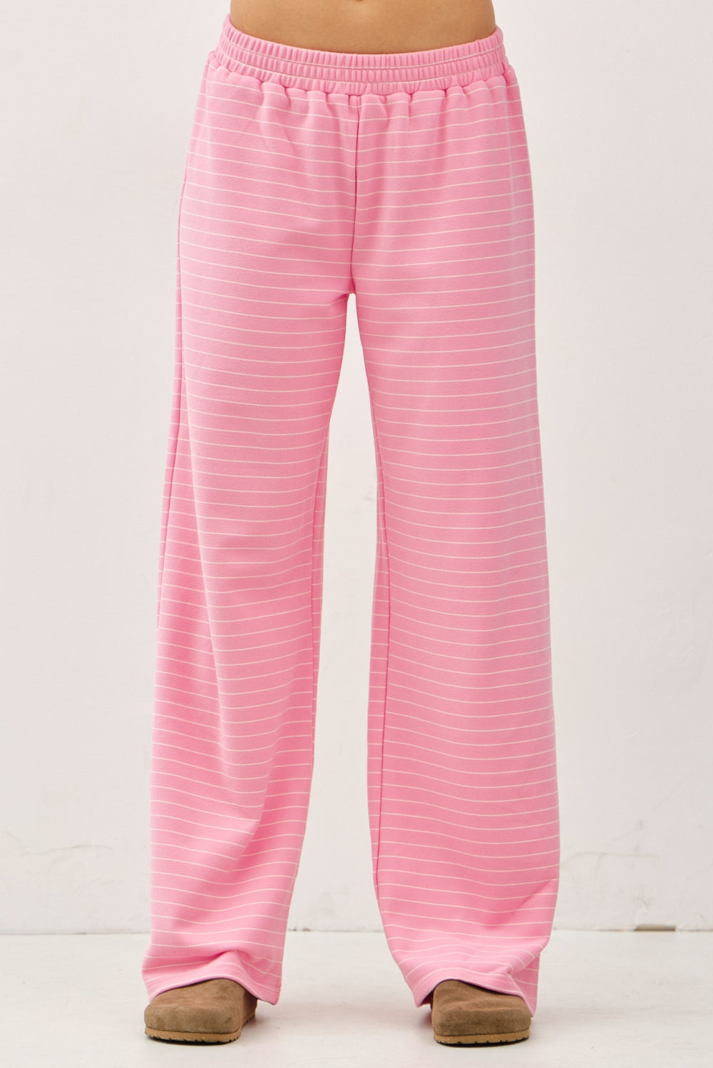 Women's flowy wide-leg lounge pants in bubblegum pink and ivory micro-stripes featuring a flat elastic waistband and relaxed silhouette.