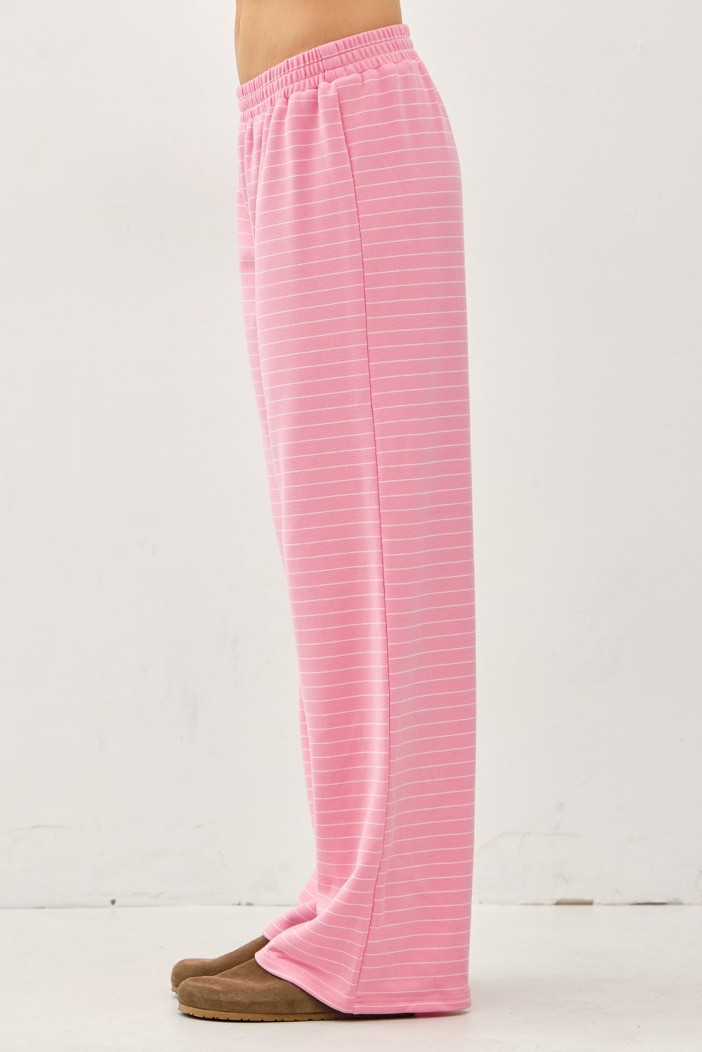 Women's flowy wide-leg lounge pants in bubblegum pink and ivory micro-stripes featuring a flat elastic waistband and relaxed silhouette.