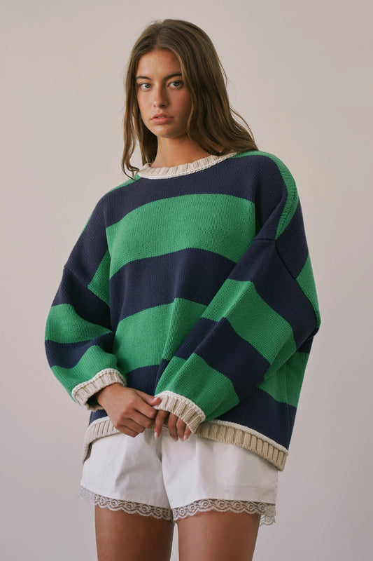 A women's heavy-knit oversized pullover sweater featuring emerald green and navy horizontal stripes with oatmeal cream ribbed crew neckline, cuffs, and hem.