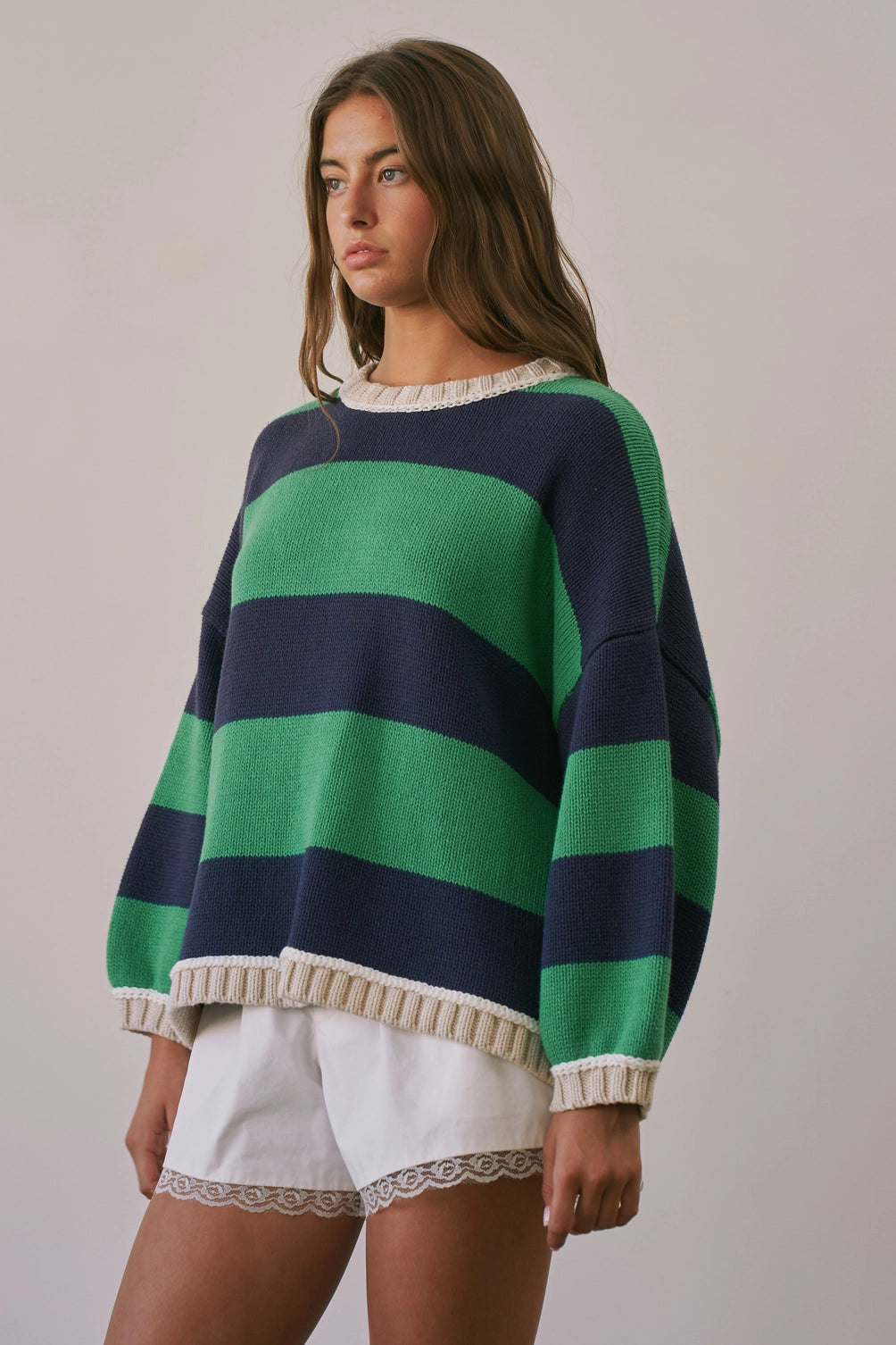 A women's heavy-knit oversized pullover sweater featuring emerald green and navy horizontal stripes with oatmeal cream ribbed crew neckline, cuffs, and hem.