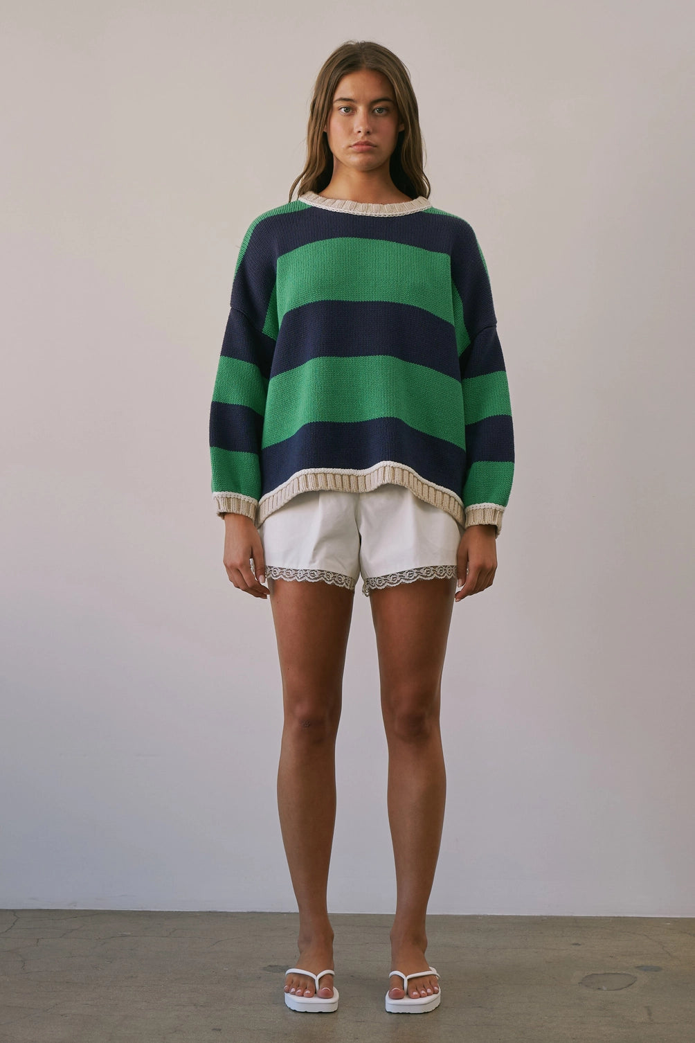 A women's heavy-knit oversized pullover sweater featuring emerald green and navy horizontal stripes with oatmeal cream ribbed crew neckline, cuffs, and hem.