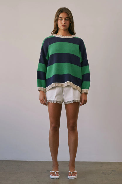 A women's heavy-knit oversized pullover sweater featuring emerald green and navy horizontal stripes with oatmeal cream ribbed crew neckline, cuffs, and hem.