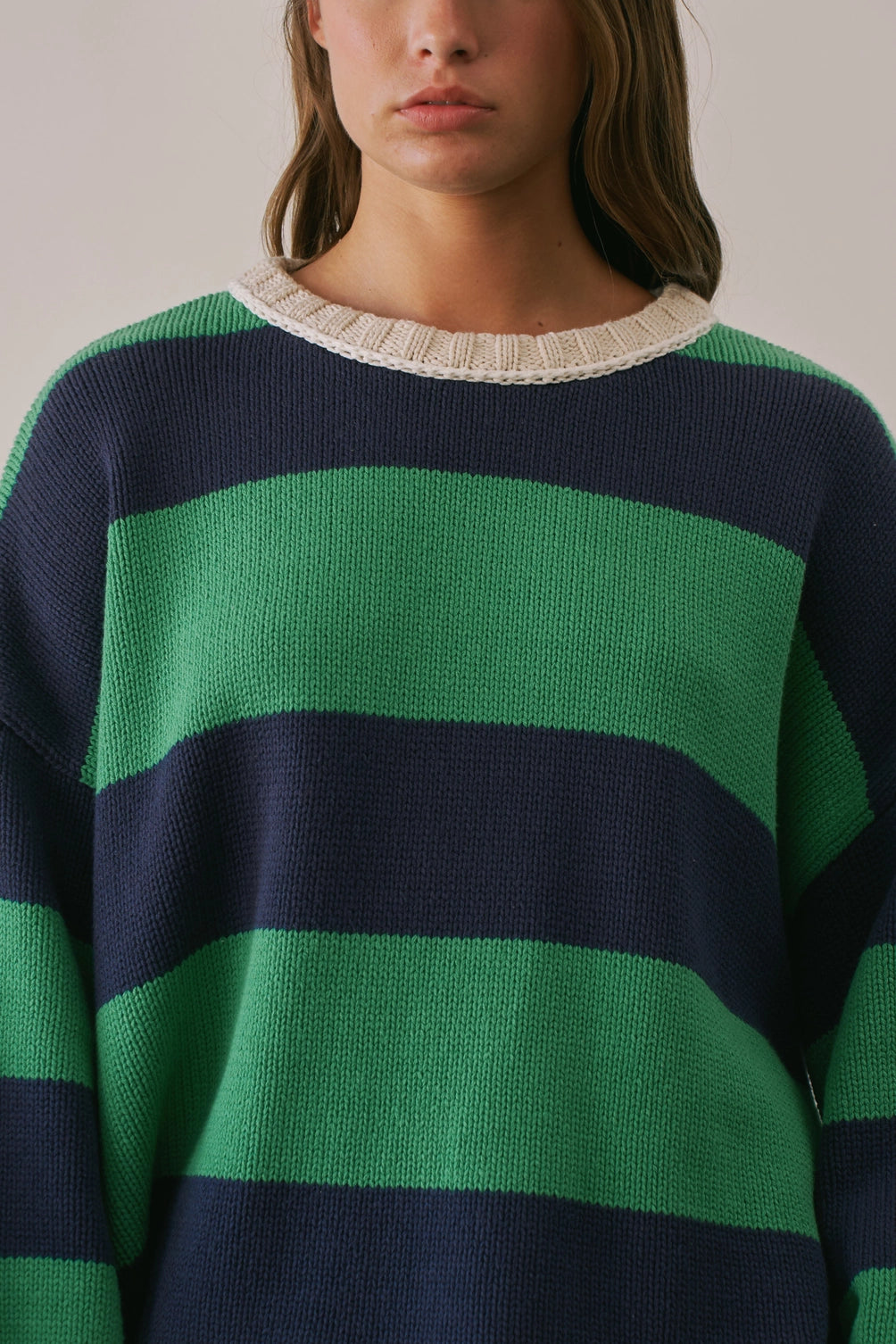 A women's heavy-knit oversized pullover sweater featuring emerald green and navy horizontal stripes with oatmeal cream ribbed crew neckline, cuffs, and hem.
