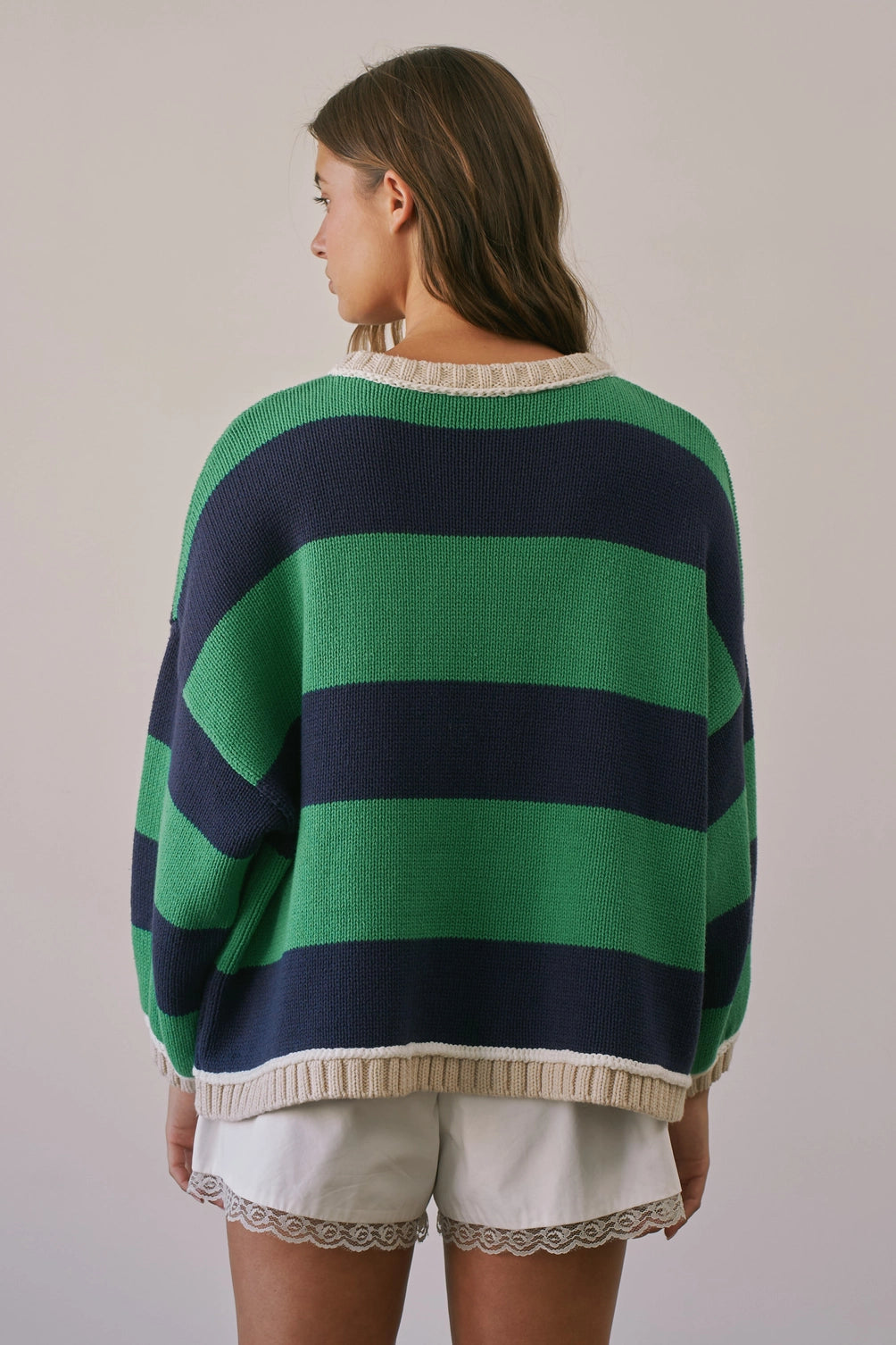 A women's heavy-knit oversized pullover sweater featuring emerald green and navy horizontal stripes with oatmeal cream ribbed crew neckline, cuffs, and hem.