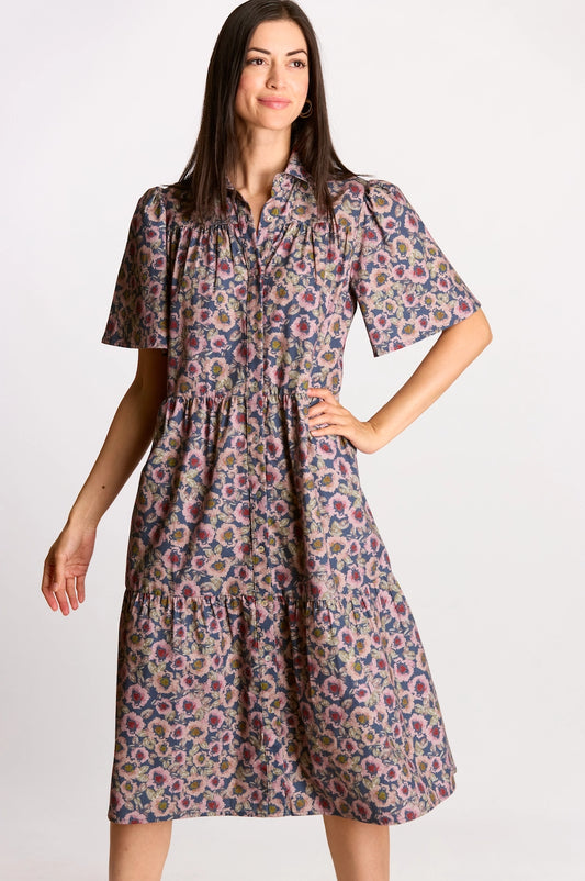 A navy and mauve floral print midi dress featuring a full button-up front, a structured collar, and short puff sleeves with a tiered skirt.