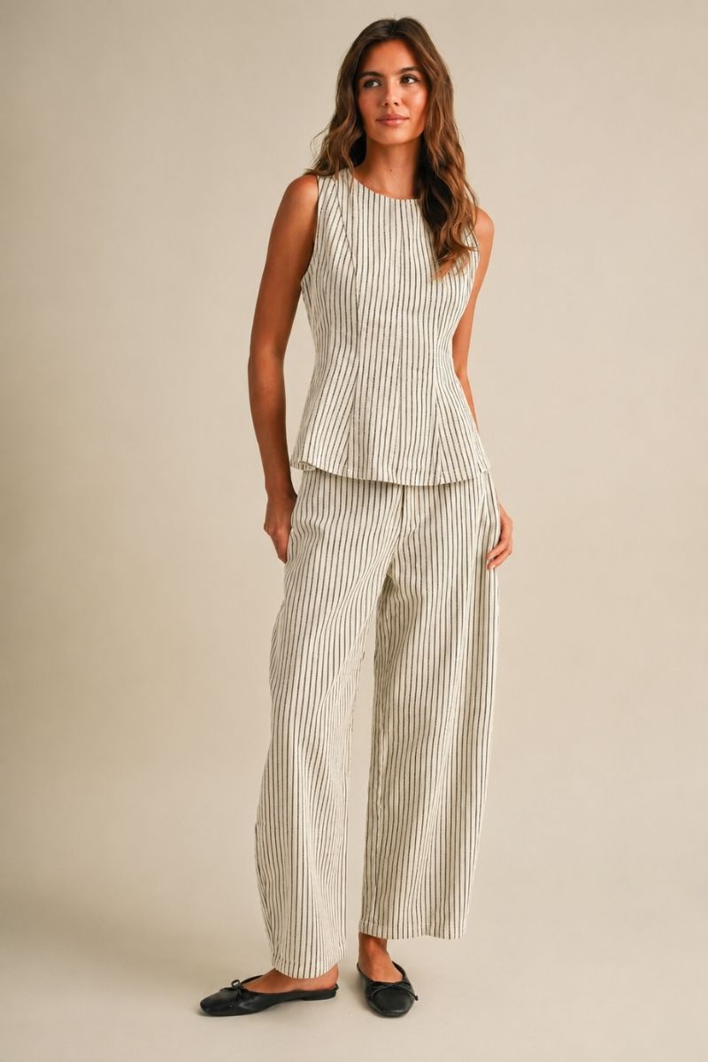 A women's two-piece matching set in a natural oatmeal and black pinstripe pattern featuring a sleeveless round-neck peplum top and relaxed wide barrel-leg pants paired with black flats.