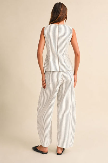A women's two-piece matching set in a natural oatmeal and black pinstripe pattern featuring a sleeveless round-neck peplum top and relaxed wide barrel-leg pants paired with black flats.