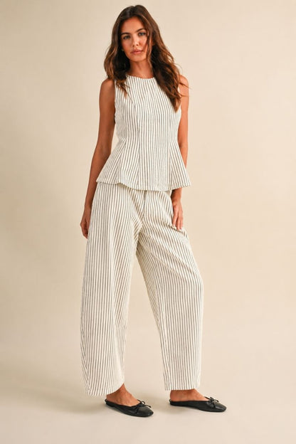 A women's two-piece matching set in a natural oatmeal and black pinstripe pattern featuring a sleeveless round-neck peplum top and relaxed wide barrel-leg pants paired with black flats.