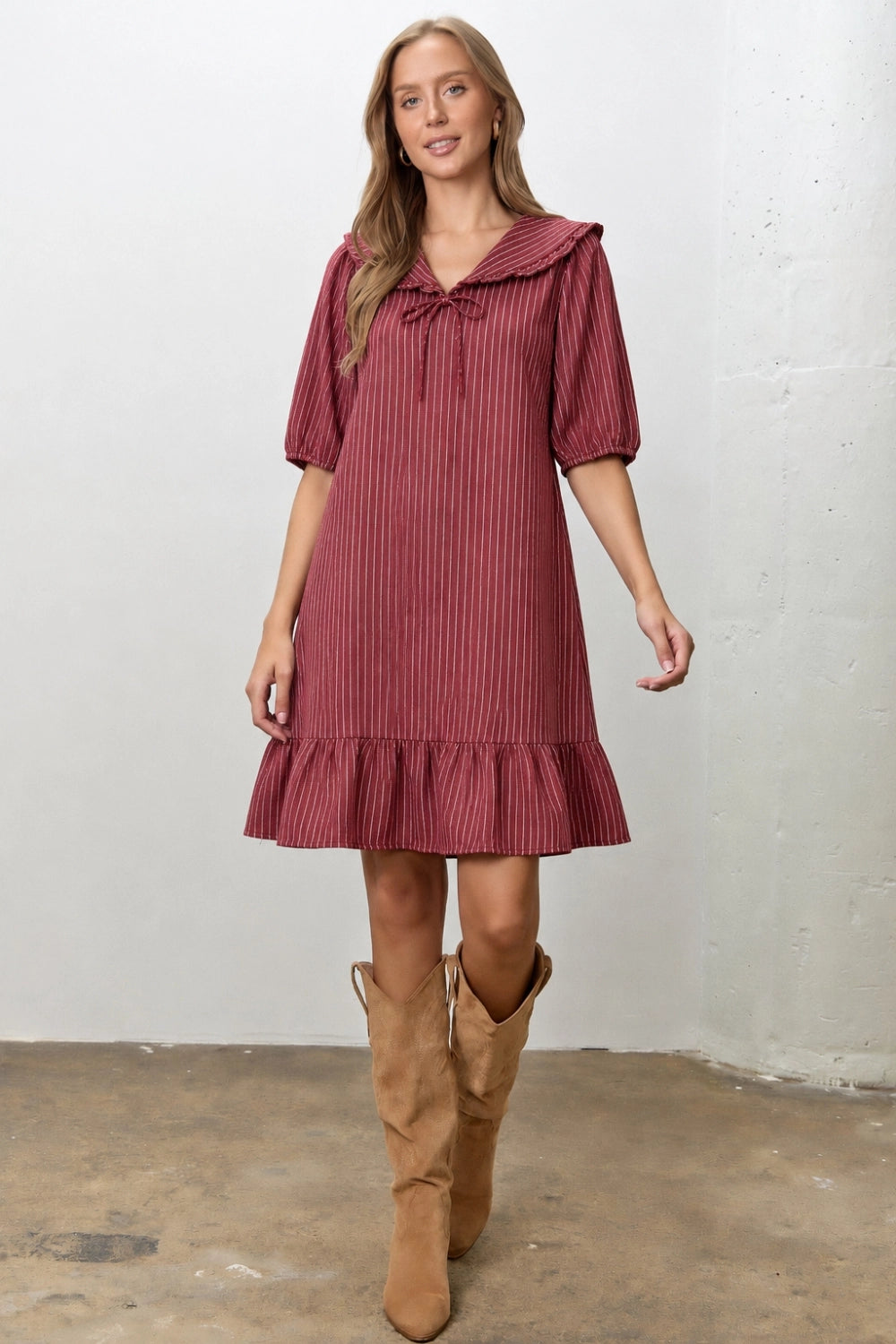 A women's relaxed short-sleeve shift dress in dark red and ivory striped denim featuring an oversized sailor collar with a tie neckline and a ruffled hem.