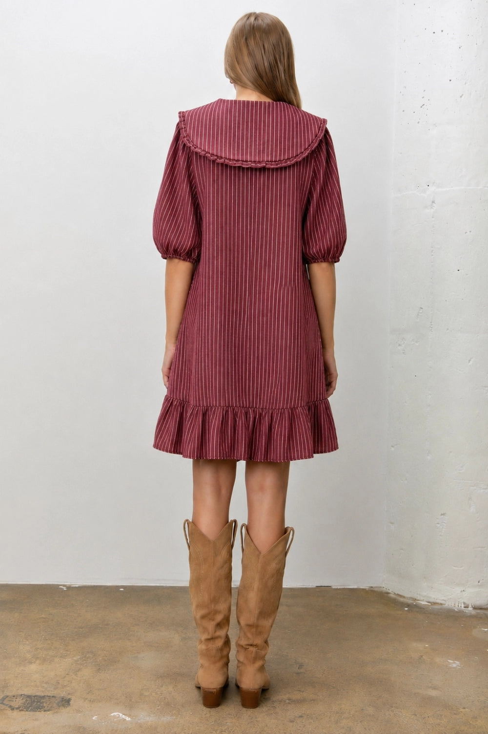 A women's relaxed short-sleeve shift dress in dark red and ivory striped denim featuring an oversized sailor collar with a tie neckline and a ruffled hem.