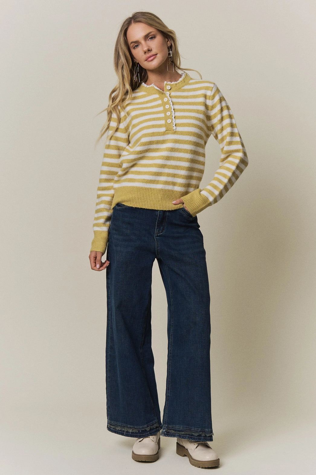 A women's long-sleeve knit henley sweater in mustard yellow and cream horizontal stripes featuring a white eyelet lace trim along the neckline and button placket.