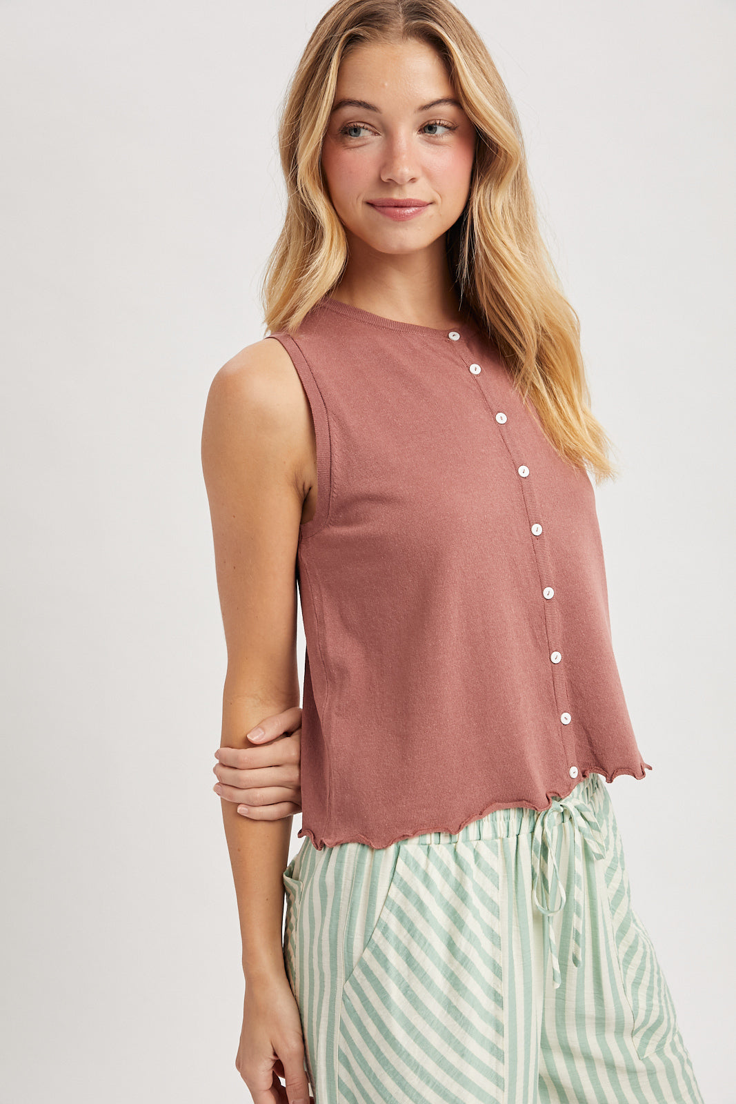 A sleeveless button-up tank top featuring a delicate lettuce-edge hem in Red, a classic crew neckline, and a lightweight knit fabric with small functional buttons.