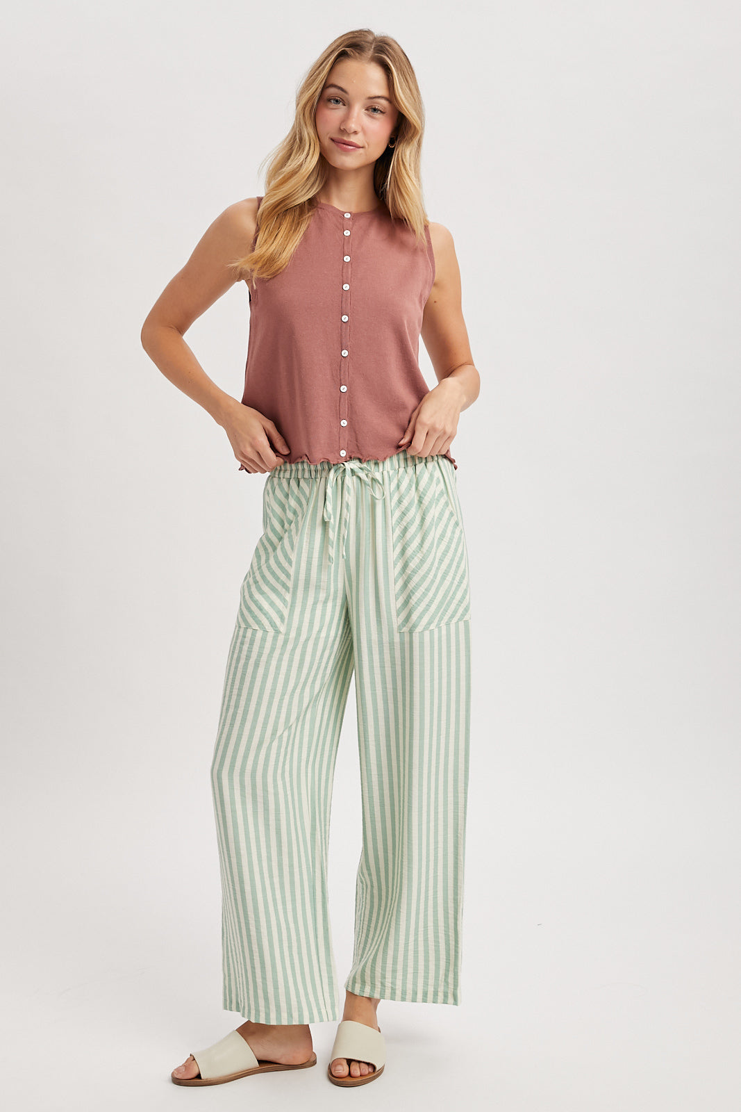 A sleeveless button-up tank top featuring a delicate lettuce-edge hem in Red, a classic crew neckline, and a lightweight knit fabric with small functional buttons.