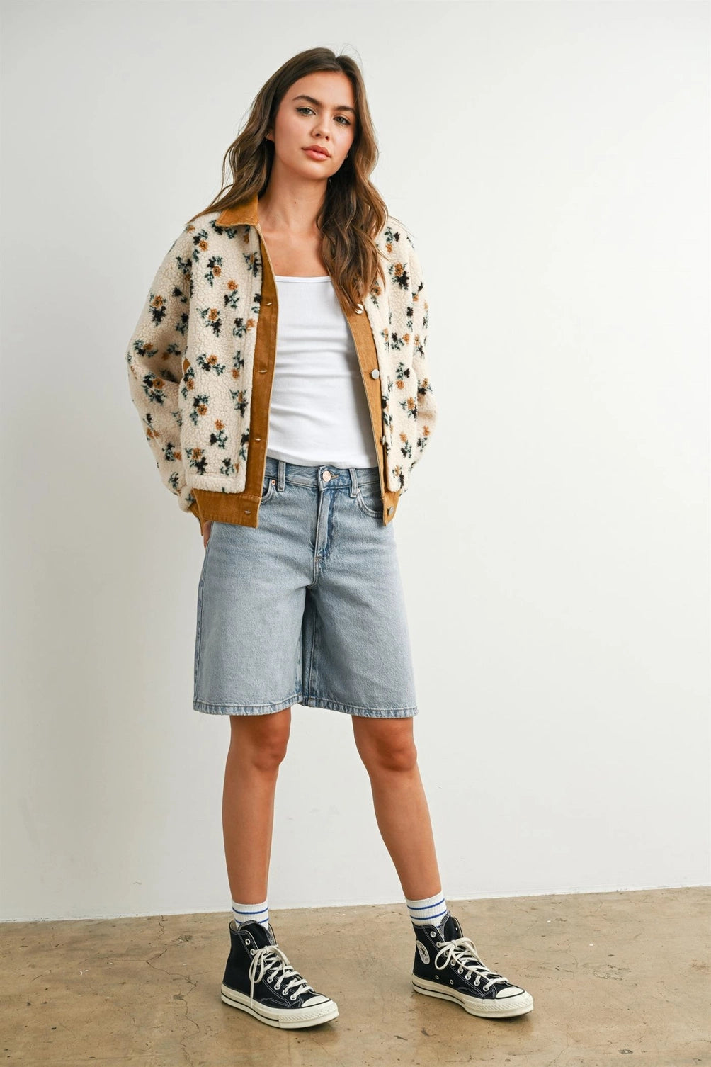 A women's cream floral printed plush sherpa fleece jacket featuring camel brown twill contrast trim, front button closures, and side pockets.
