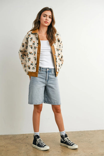 A women's cream floral printed plush sherpa fleece jacket featuring camel brown twill contrast trim, front button closures, and side pockets.