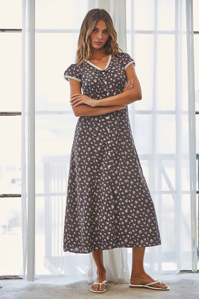 A women's short flutter sleeve midi dress in antique black featuring a pink vintage rose floral print, white scalloped lace trim along the V-neckline, and a full button-down front.