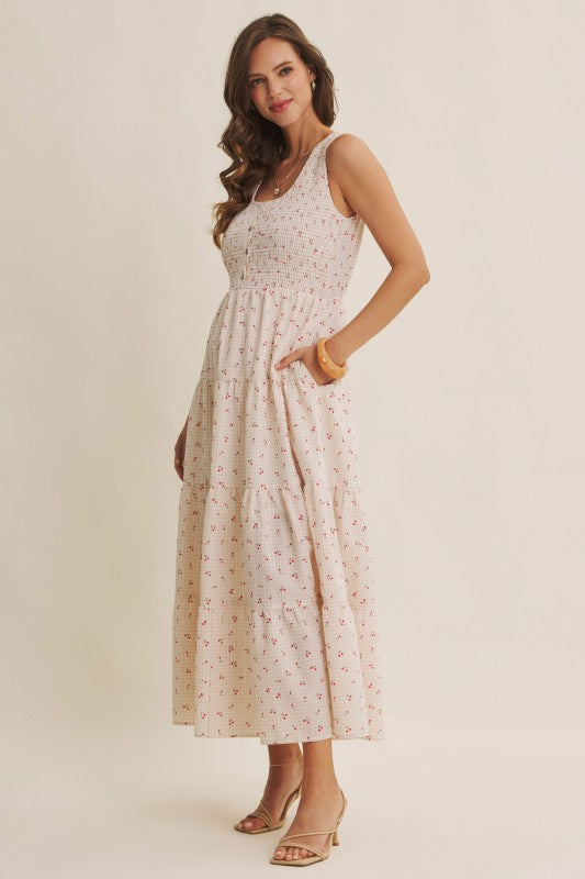 Cherry gingham print maxi dress in the color biscuit. The dress has a smocked bust, round neck, button-down detail, side pockets and comes lined. 