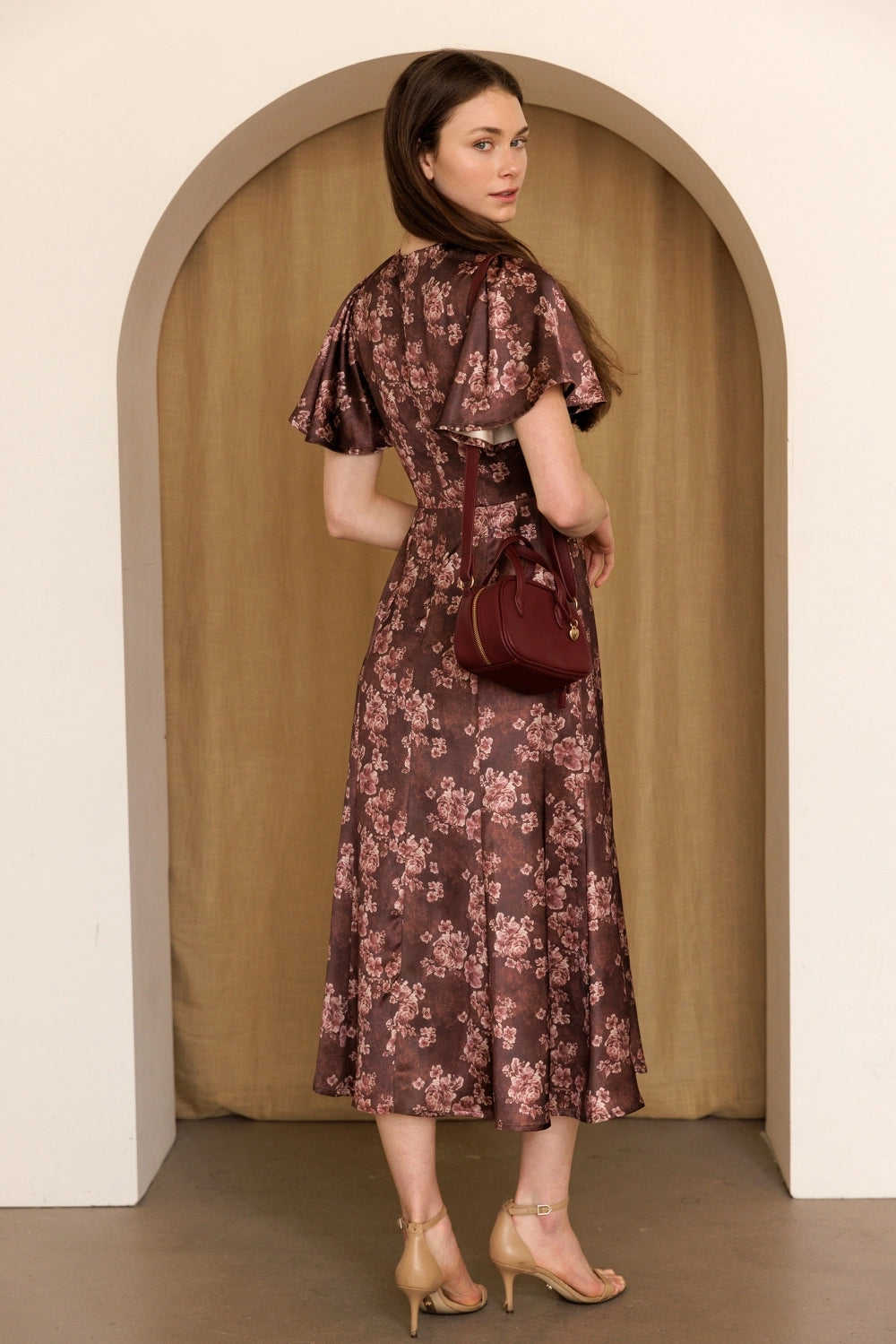 A women's dusty mauve floral print midi dress featuring short flutter sleeves, a structured smocked bodice, and an A-line skirt