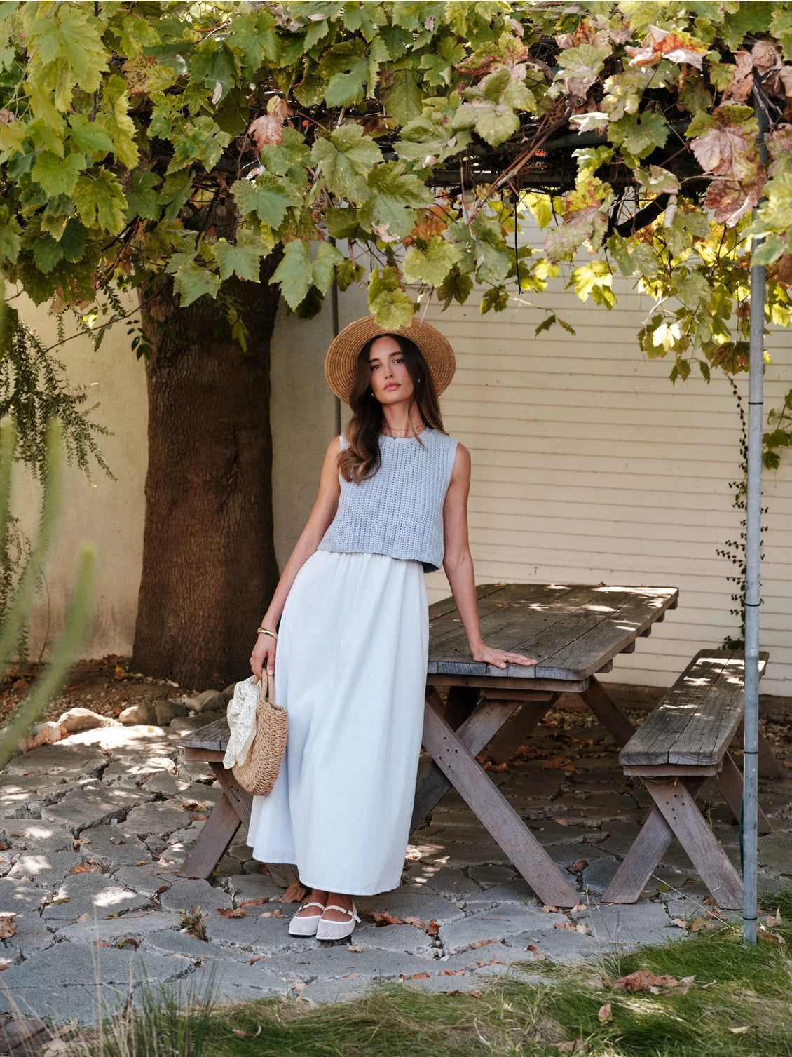 A women's sky blue mixed media midi dress featuring a sleeveless open-knit sweater vest top and an attached gathered striped midi skirt.