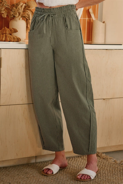 Olive and oatmeal vertical striped linen-blend pants featuring a high-rise elastic drawstring waistband, a relaxed tapered leg, and functional side utility pockets.