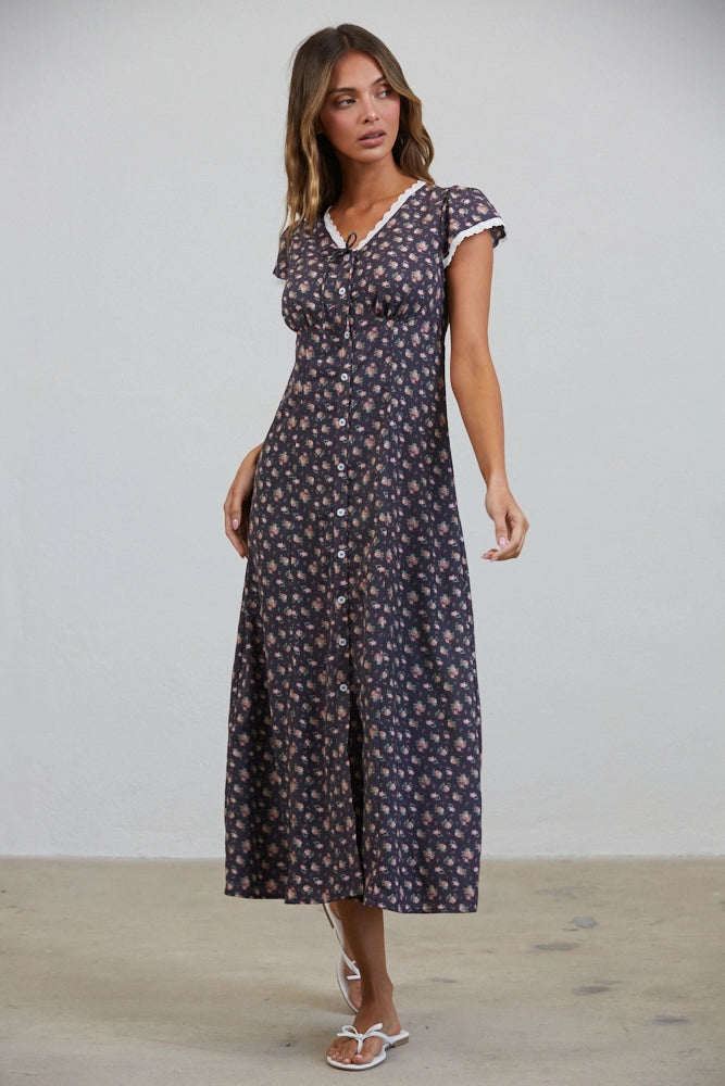 A women's short flutter sleeve midi dress in antique black featuring a pink vintage rose floral print, white scalloped lace trim along the V-neckline, and a full button-down front.