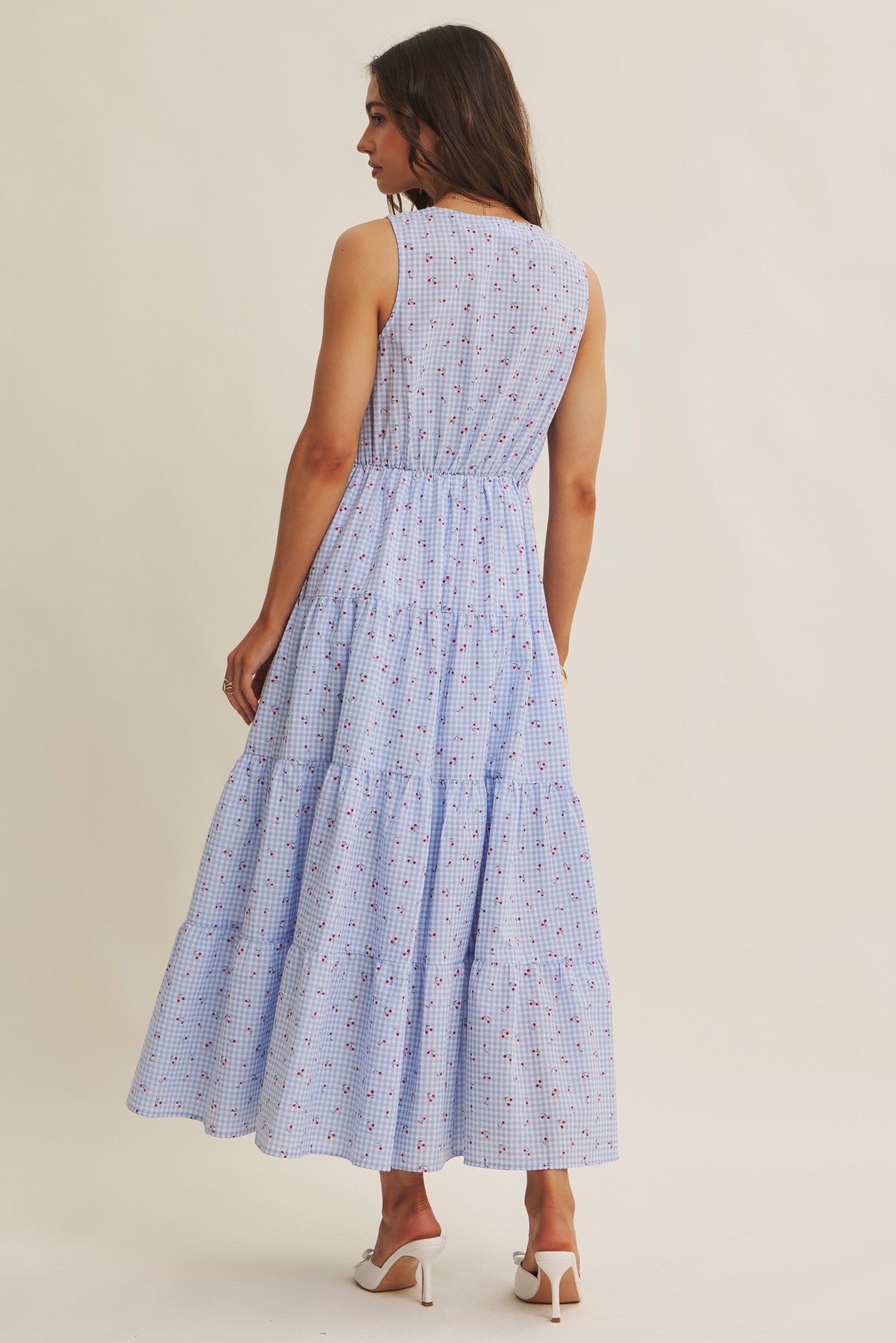 Cherry gingham print maxi dress in the color sky blue. The dress has a smocked bust, round neck, button-down detail, side pockets and comes lined. 
