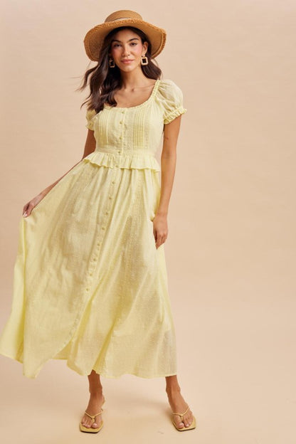 Maxi Dress in Lemon Water Yellow is a lightweight, feminine yellow maxi dress featuring delicate Swiss dot fabric, puff sleeves, and a flattering button-front bodice